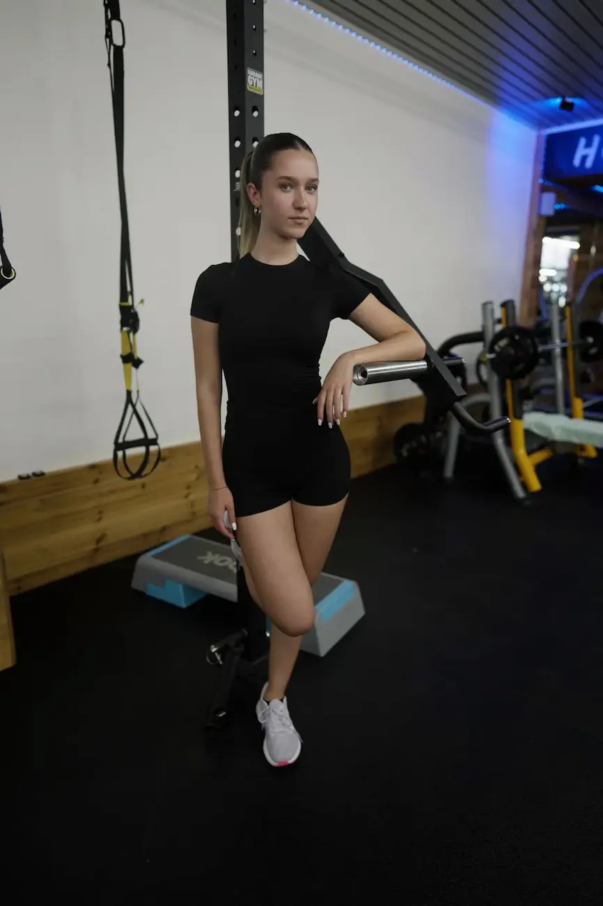 Mitglied posiert mit TRX-Bändern im Kraftbereich